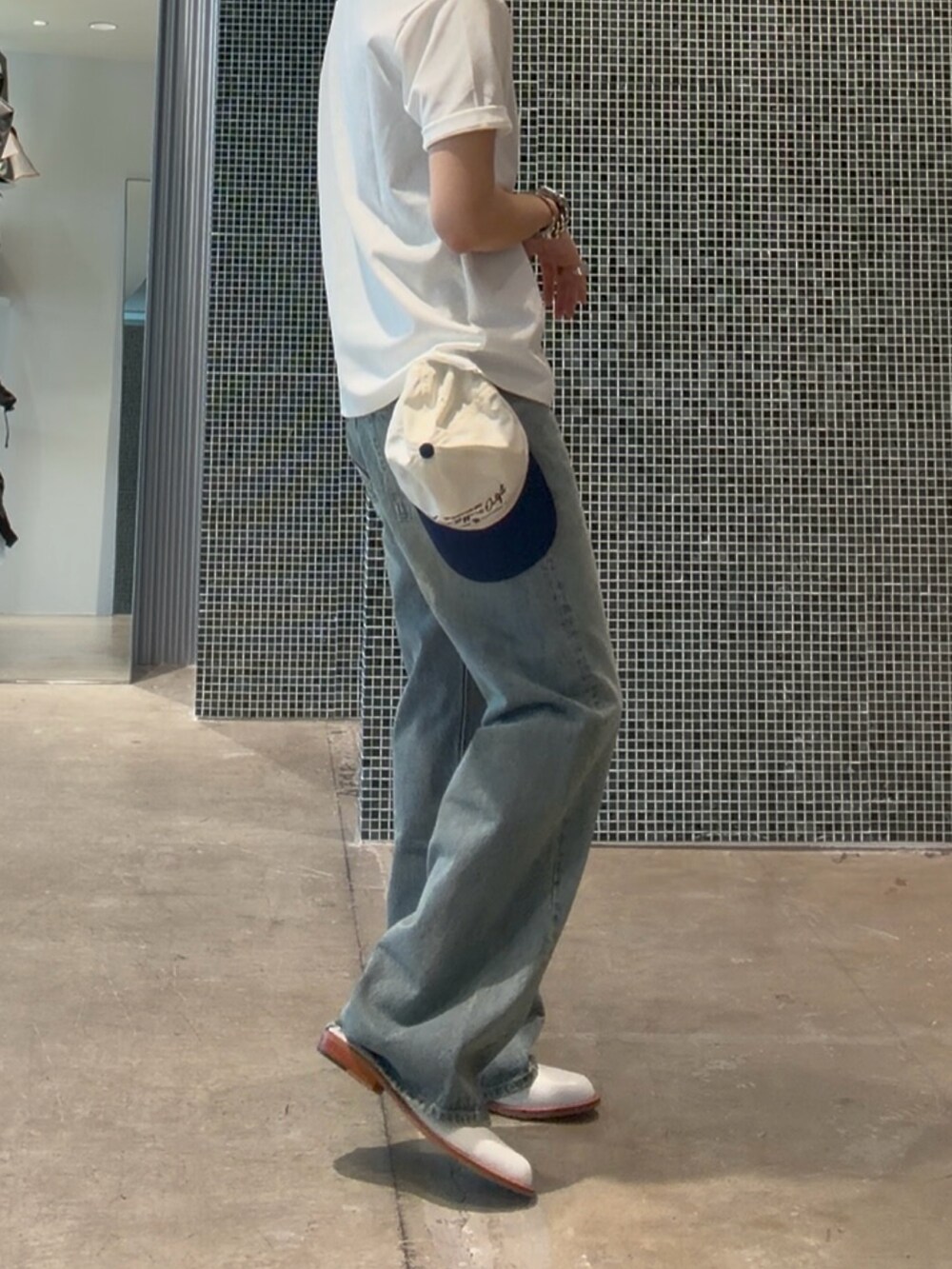 ホワイト系のTシャツ/カットソー、ブルー系のデニムパンツ、ブルー系のキャップを着用したメンズの夏コーディネートの5枚目の写真