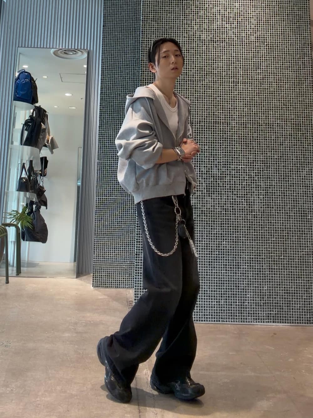 ブラック系のデニムパンツ、ホワイト系のタンクトップ、グレー系のパーカーを着用したメンズの夏コーディネートの3枚目の写真