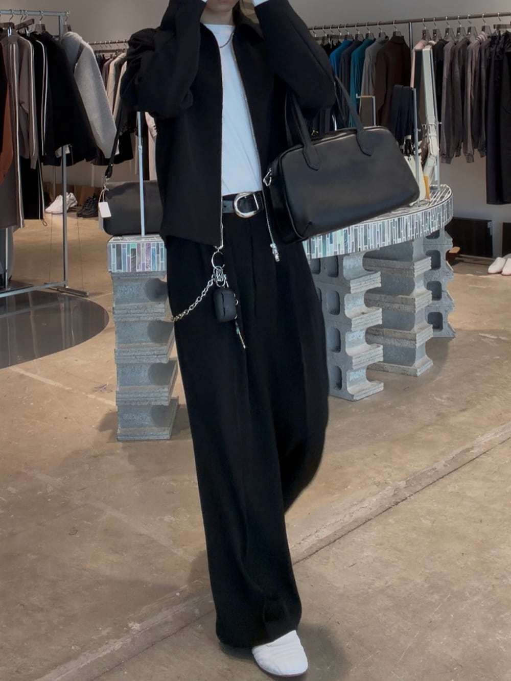 ブラック系のブルゾン、ブラック系のショルダーバッグ、ブラック系のスラックスを着用したメンズの春コーディネートの2枚目の写真