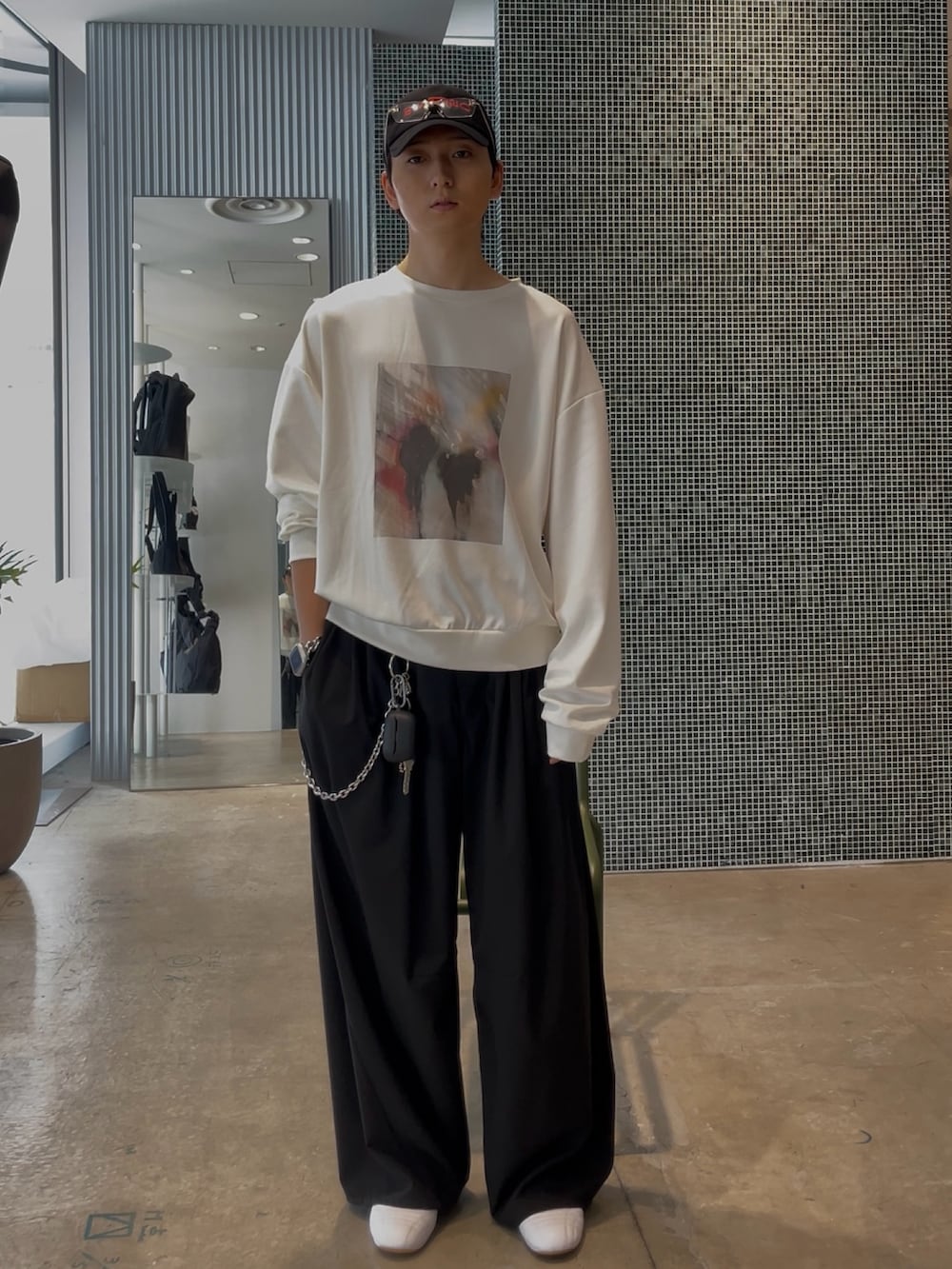 ブラック系のブルゾン、ホワイト系のスウェット、ブラック系のスラックスを着用したメンズの春コーディネートの2枚目の写真