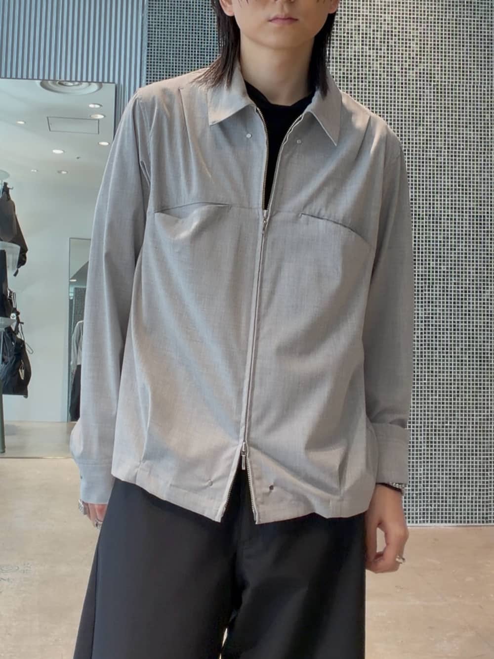 グレー系のシャツ/ブラウス、ブラック系のスラックス、ブラック系のハンドバッグを着用したメンズの春コーディネートの3枚目の写真