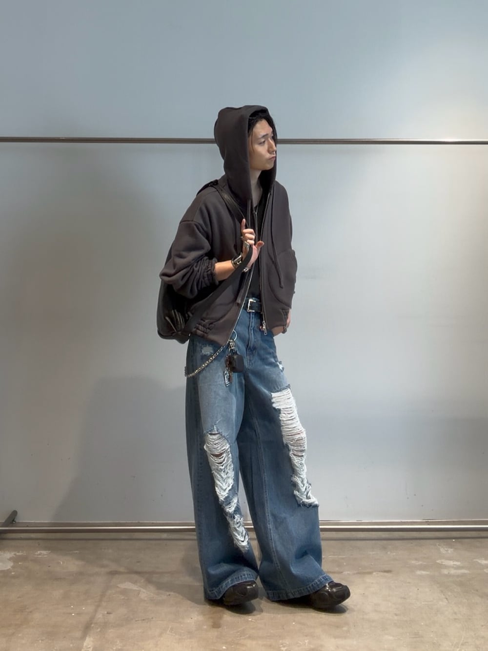 ブルー系のデニムパンツ、グレー系のパーカー、ブラック系のベルトを着用したメンズの夏コーディネートの6枚目の写真