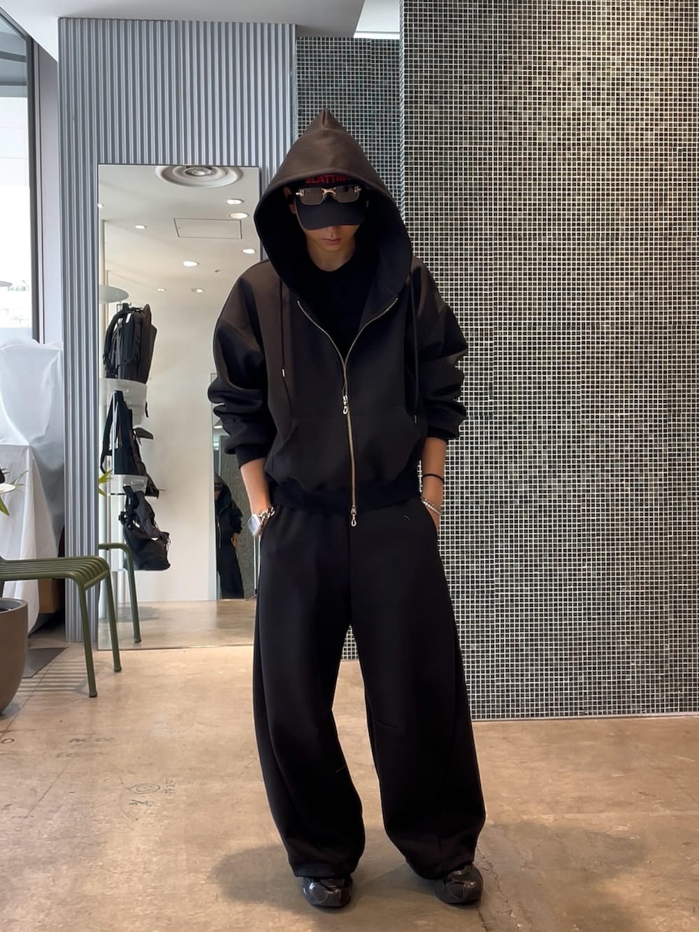 ブラック系のパーカー、ブラック系のその他パンツを着用したメンズの春コーディネートの2枚目の写真