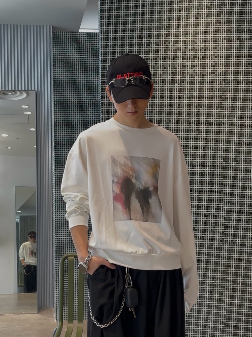 ブラック系のブルゾン、ホワイト系のスウェット、ブラック系のスラックスを着用したメンズの春コーディネートの5枚目の写真