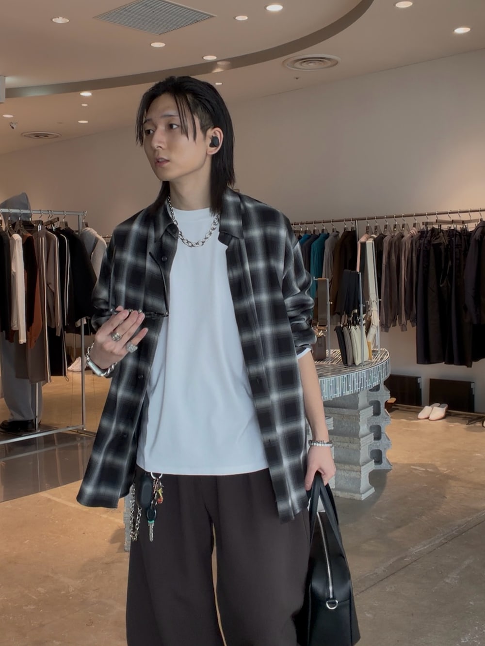 ブラック系のシャツ/ブラウス、ブラック系のスラックス、ブラック系のショルダーバッグを着用したメンズの春コーディネートの2枚目の写真