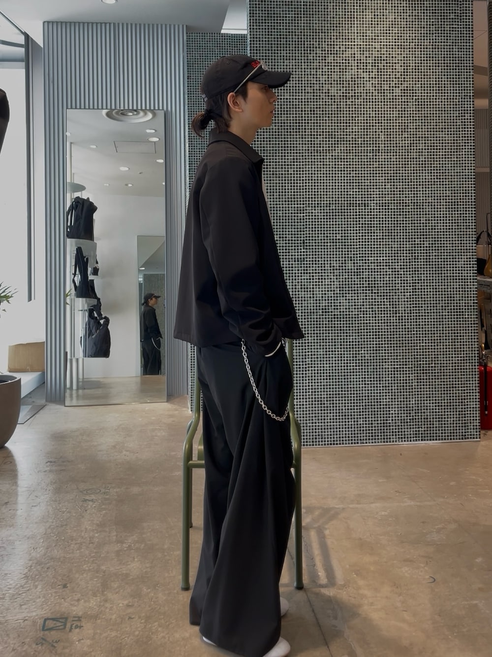 ブラック系のブルゾン、ホワイト系のスウェット、ブラック系のスラックスを着用したメンズの春コーディネートの3枚目の写真