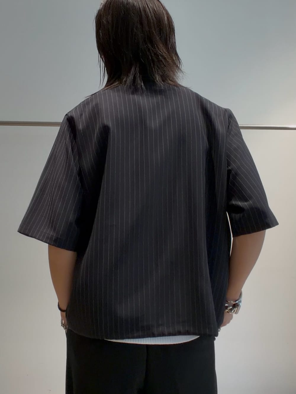 ブラック系のシャツ/ブラウス、ブラック系のスラックス、ホワイト系のタンクトップを着用したメンズの夏コーディネートの5枚目の写真