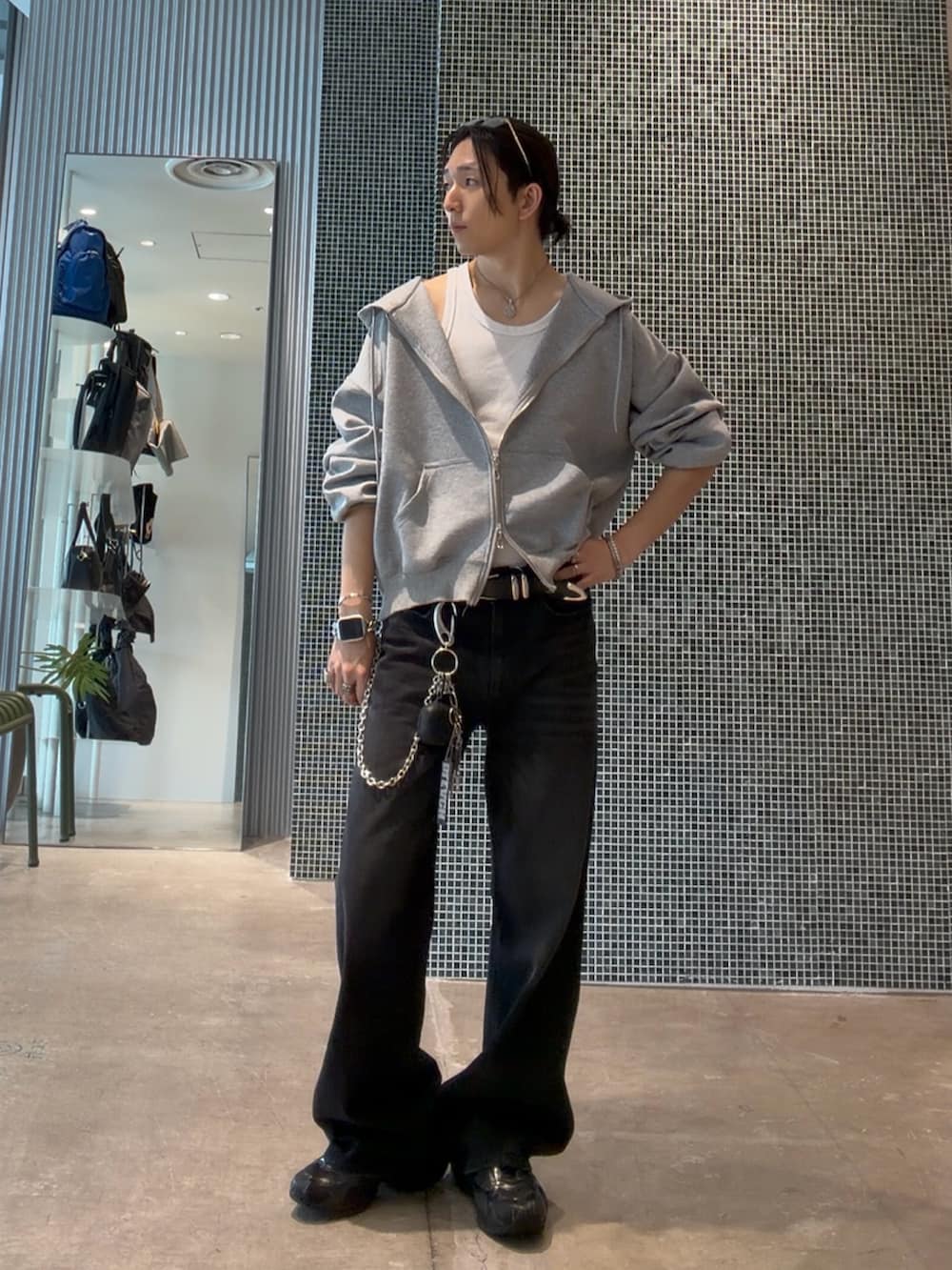 ブラック系のデニムパンツ、ホワイト系のタンクトップ、グレー系のパーカーを着用したメンズの夏コーディネートの2枚目の写真