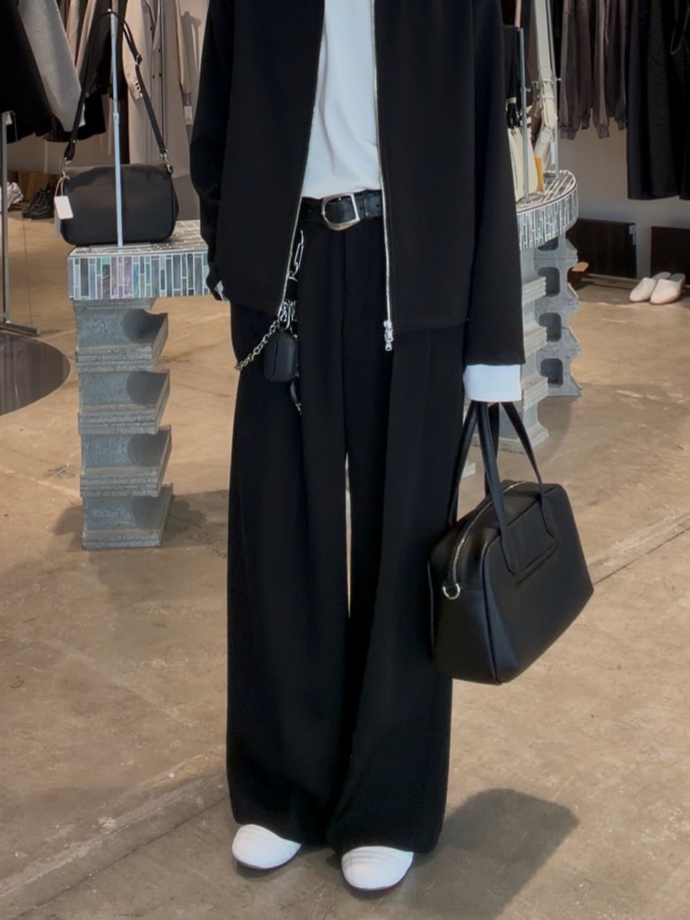 ブラック系のブルゾン、ブラック系のショルダーバッグ、ブラック系のスラックスを着用したメンズの春コーディネートの3枚目の写真