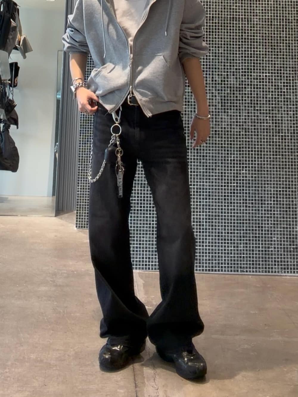 ブラック系のデニムパンツ、ホワイト系のタンクトップ、グレー系のパーカーを着用したメンズの夏コーディネートの4枚目の写真