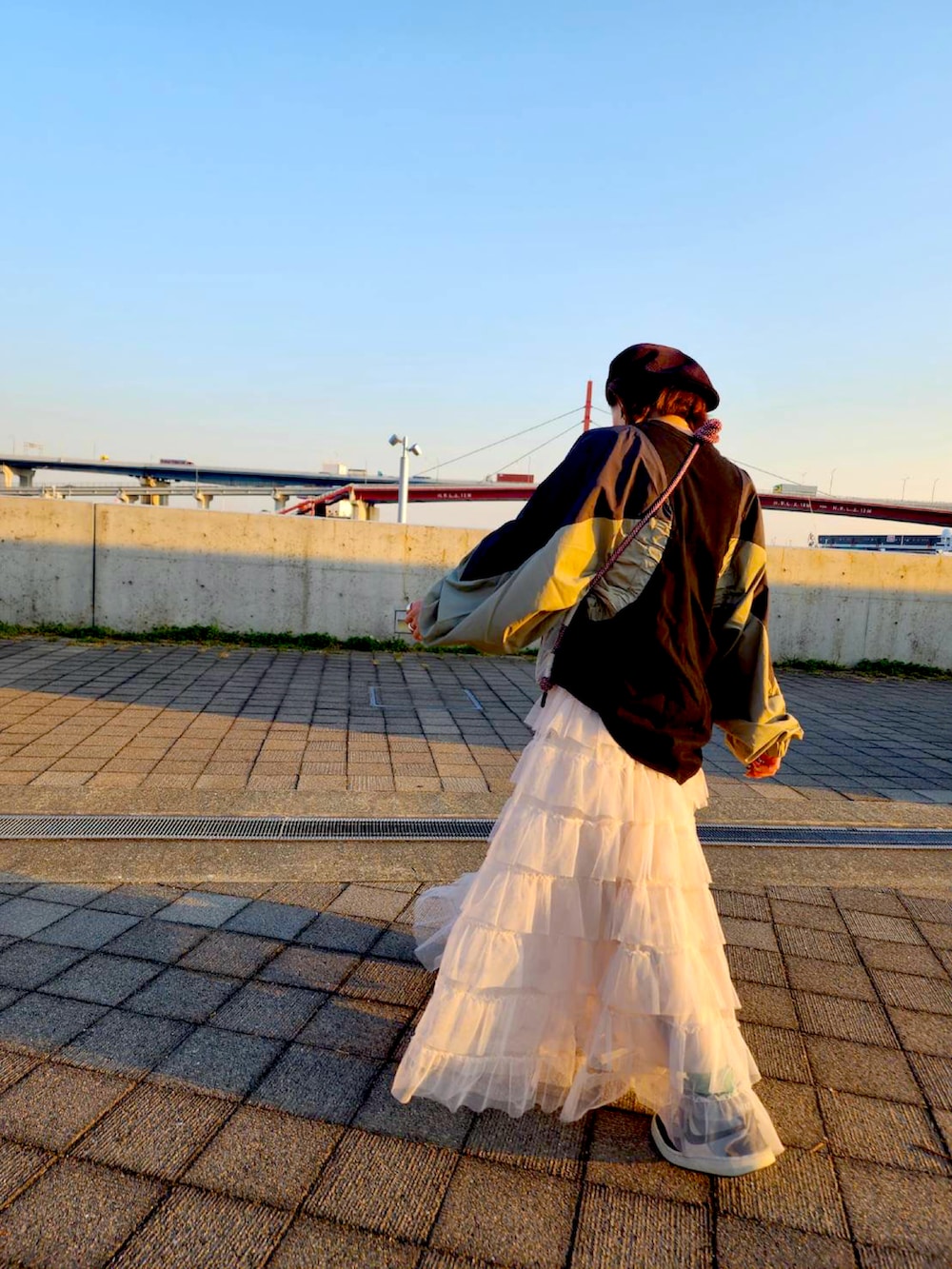 グレー系のショルダーバッグ、グレー系のスニーカー、ブラック系のキャスケットを着用したレディースの冬コーディネートの3枚目の写真