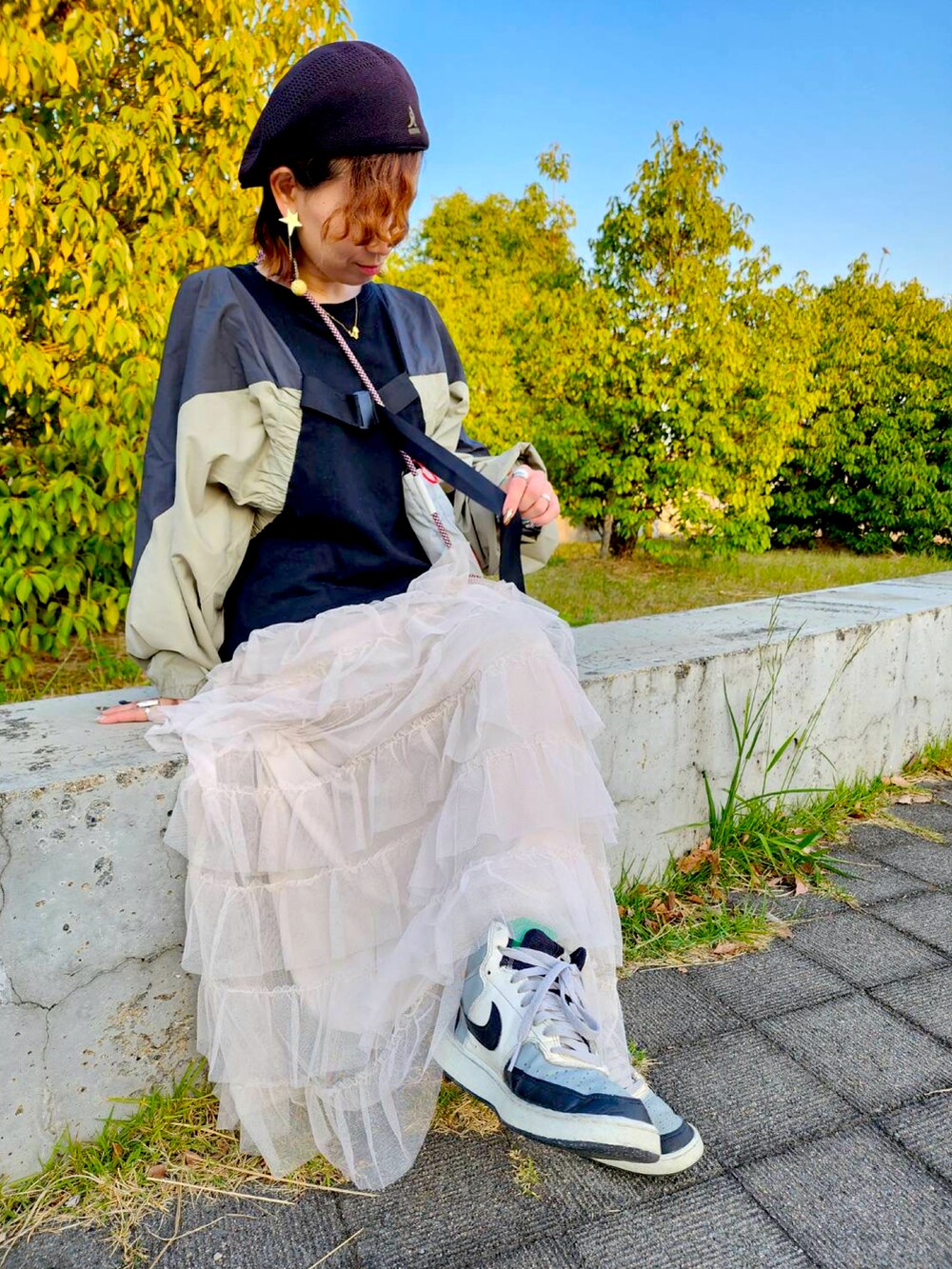 グレー系のショルダーバッグ、グレー系のスニーカー、ブラック系のキャスケットを着用したレディースの冬コーディネートの2枚目の写真