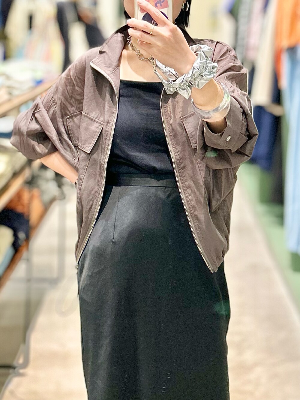 ベージュ系のブルゾン、ブラック系のスカート、ブラック系のスニーカーを着用したレディースの春コーディネートの2枚目の写真