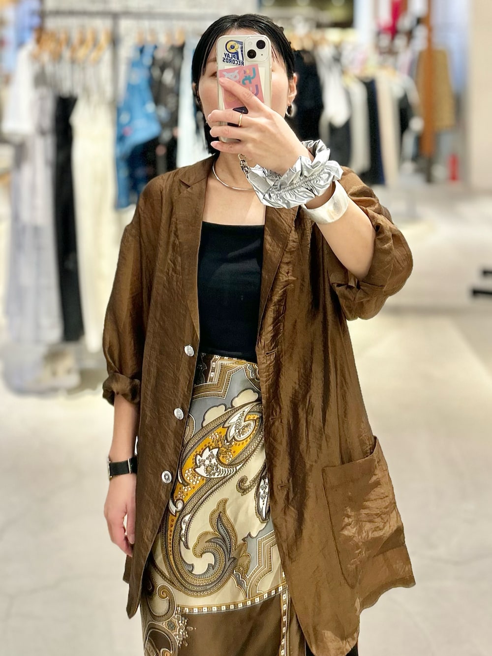 ブラウン系のテーラードジャケット、ブラック系のスラックス、ブラック系のサンダルを着用したレディースの春コーディネートの2枚目の写真