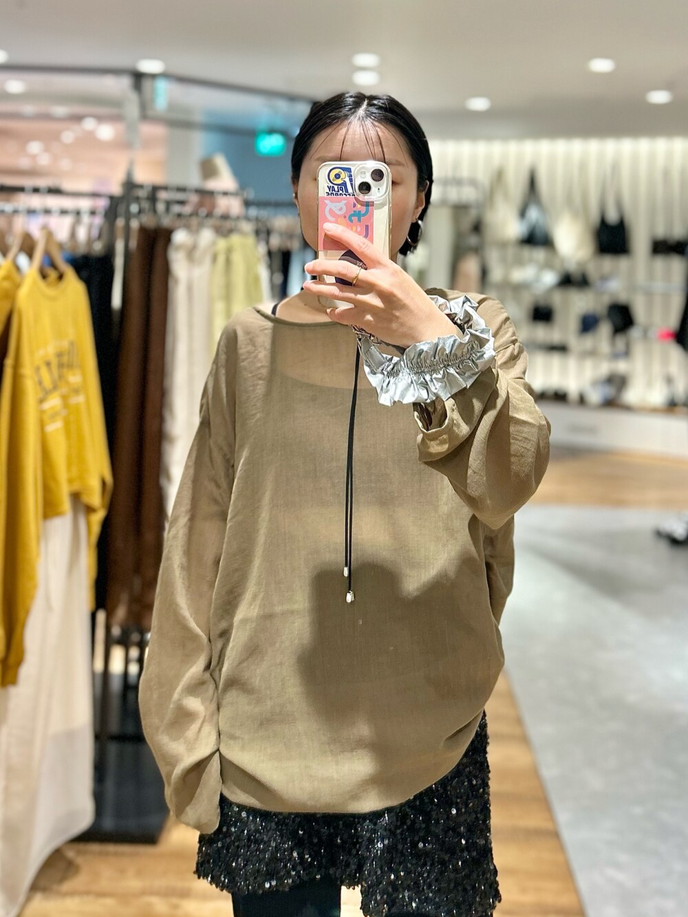 ブラウン系のチュニック、ブラック系のスカート、ブラック系のその他パンツを着用したレディースの夏コーディネートの2枚目の写真