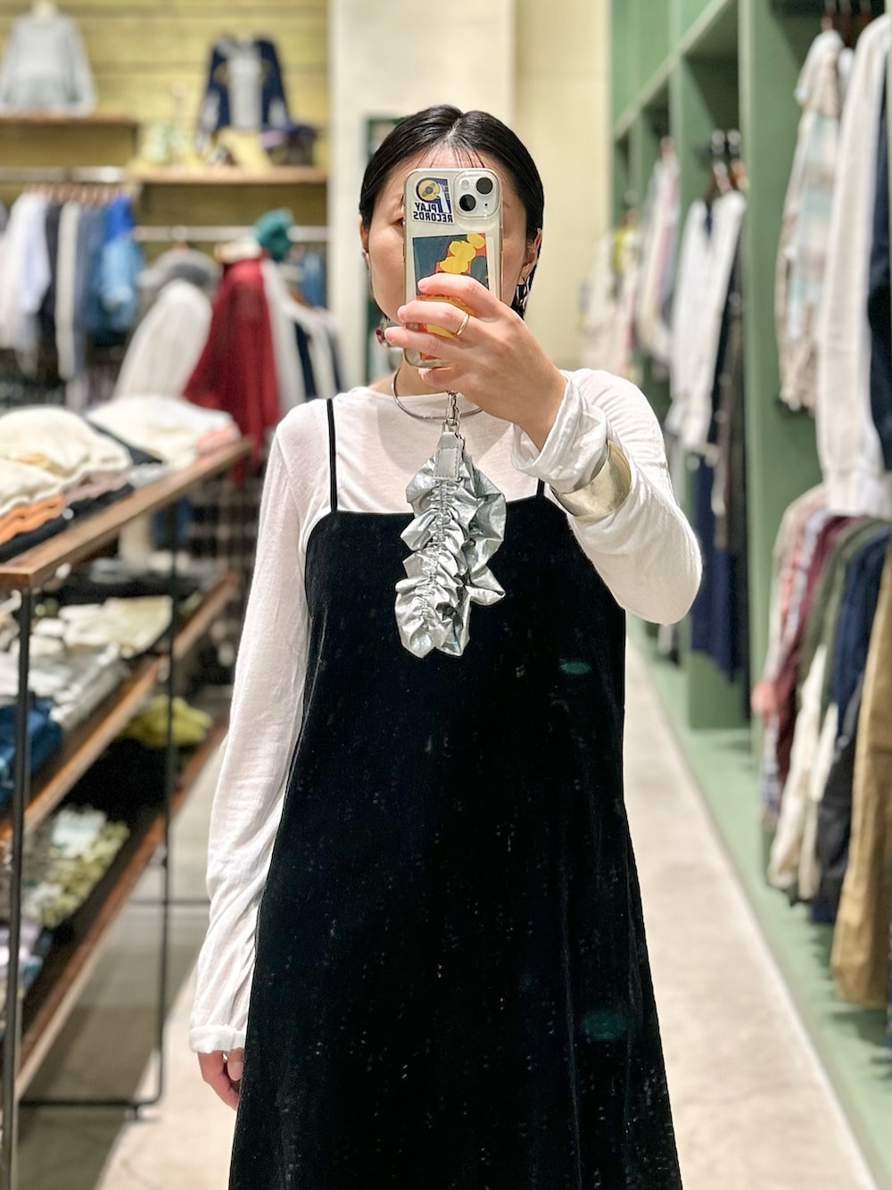 ブラック系のキャミソール、ホワイト系のTシャツ/カットソー、ブルー系のデニムパンツを着用したレディースの秋コーディネートの2枚目の写真