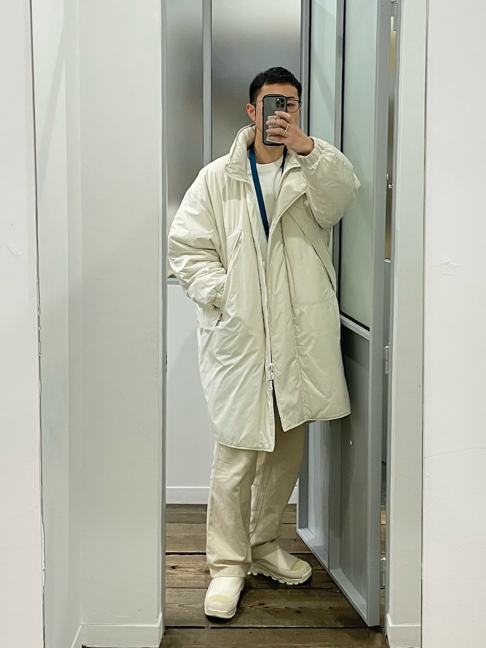 ホワイト系のダウンジャケット/コート、ホワイト系のチノパンツ、ホワイト系のブーツを着用したメンズの冬コーディネートの2枚目の写真