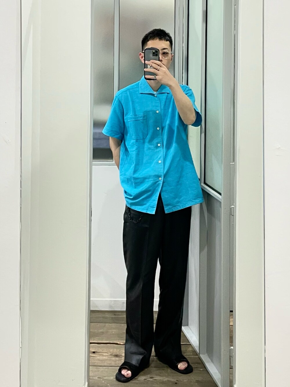 ブルー系のシャツ/ブラウス、ブラック系のスラックス、ブラック系のサンダルを着用したメンズの夏コーディネートの5枚目の写真