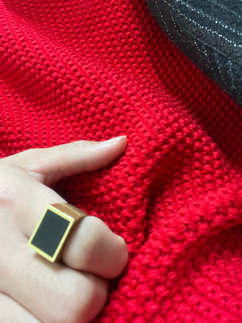 レッド系のニット/セーター、ブラック系のブーツを着用したメンズの冬コーディネートの3枚目の写真