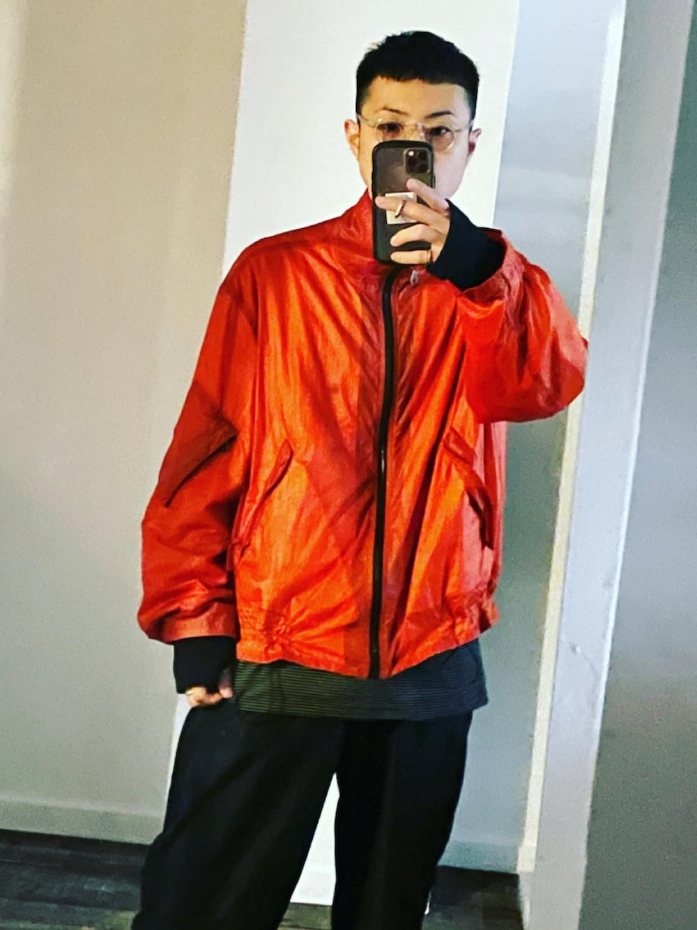 オレンジ系のナイロンジャケット、ブラック系のTシャツ/カットソー、ブラック系のその他パンツを着用したメンズの夏コーディネートの3枚目の写真