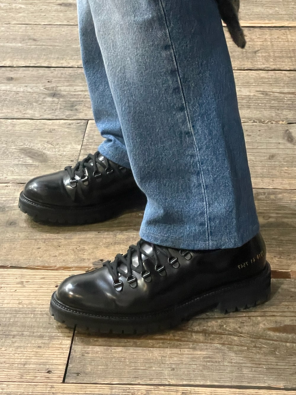 ブルー系のデニムパンツ、ブラック系のブーツ、その他のステンカラーコートを着用したメンズの冬コーディネートの3枚目の写真