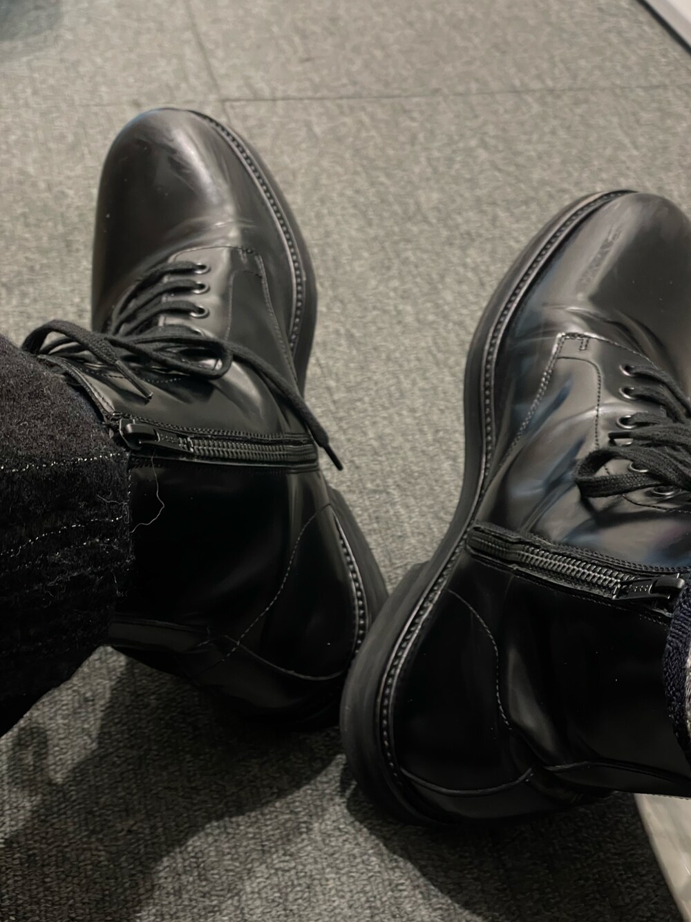 レッド系のニット/セーター、ブラック系のブーツを着用したメンズの冬コーディネートの4枚目の写真