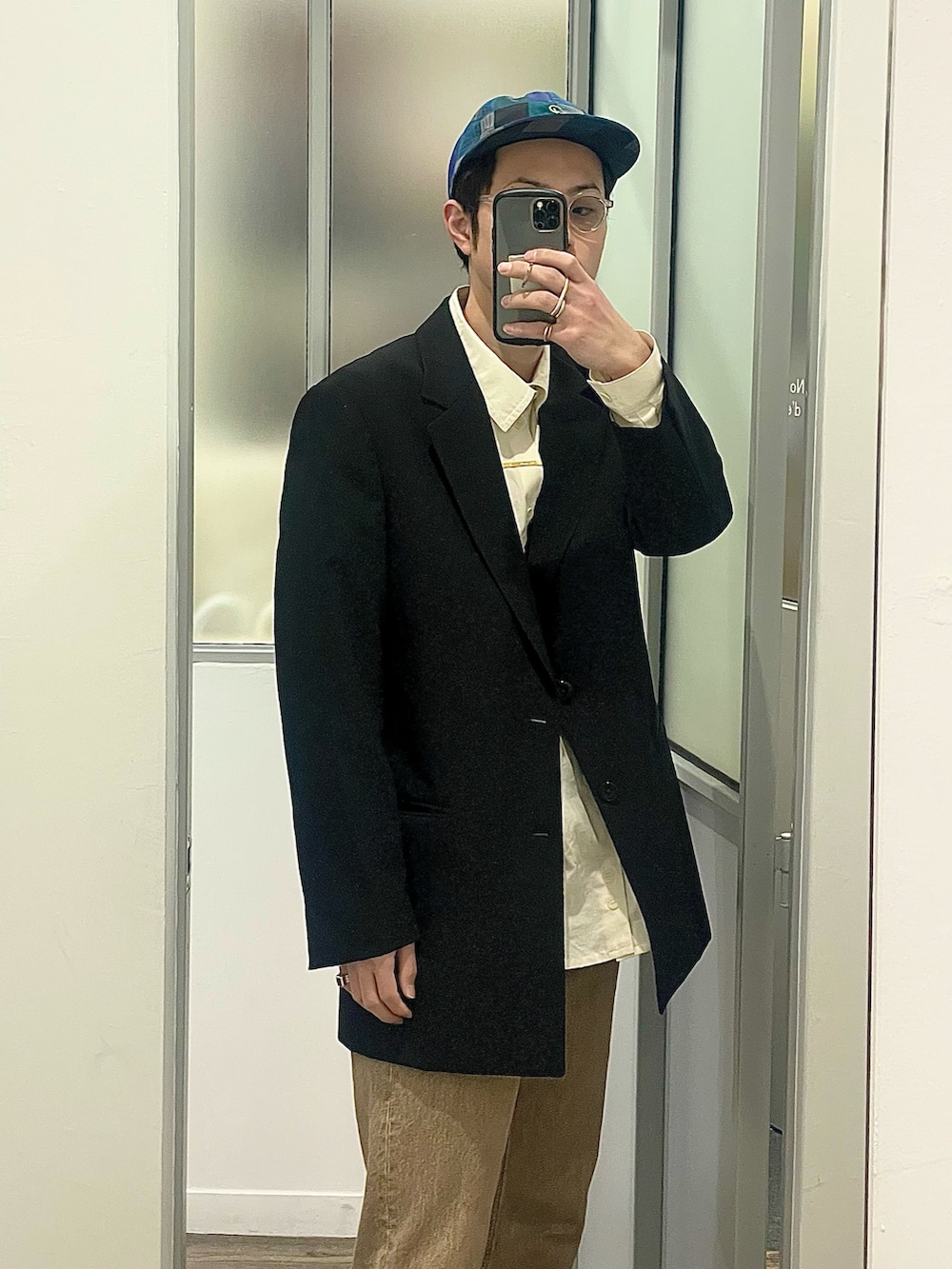 ブルー系のスニーカー、ブラック系のテーラードジャケット、ベージュ系のデニムパンツを着用したメンズの春コーディネートの2枚目の写真