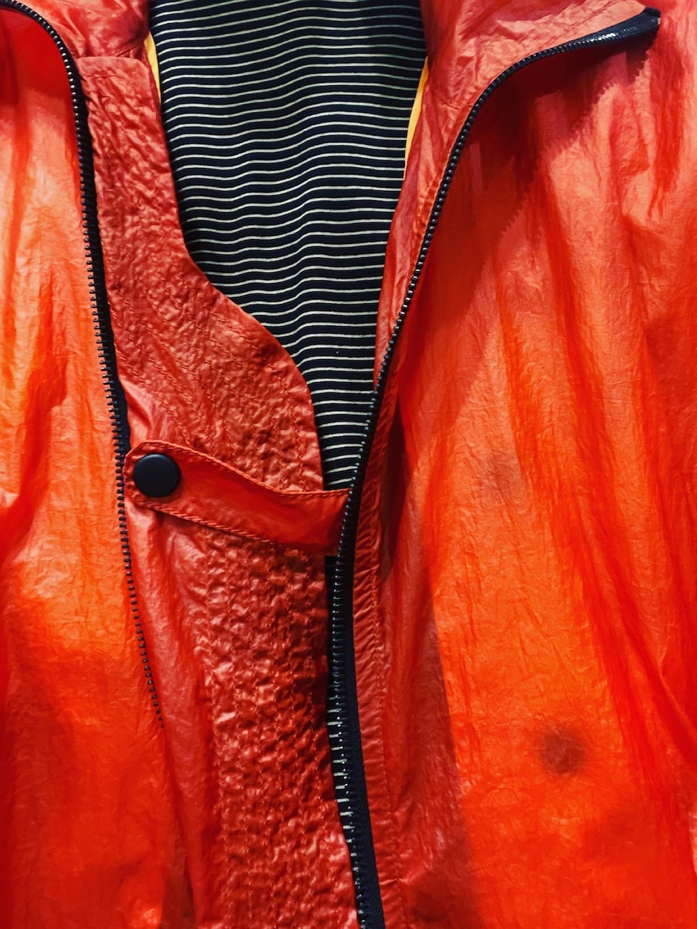 オレンジ系のナイロンジャケット、ブラック系のTシャツ/カットソー、ブラック系のその他パンツを着用したメンズの夏コーディネートの2枚目の写真