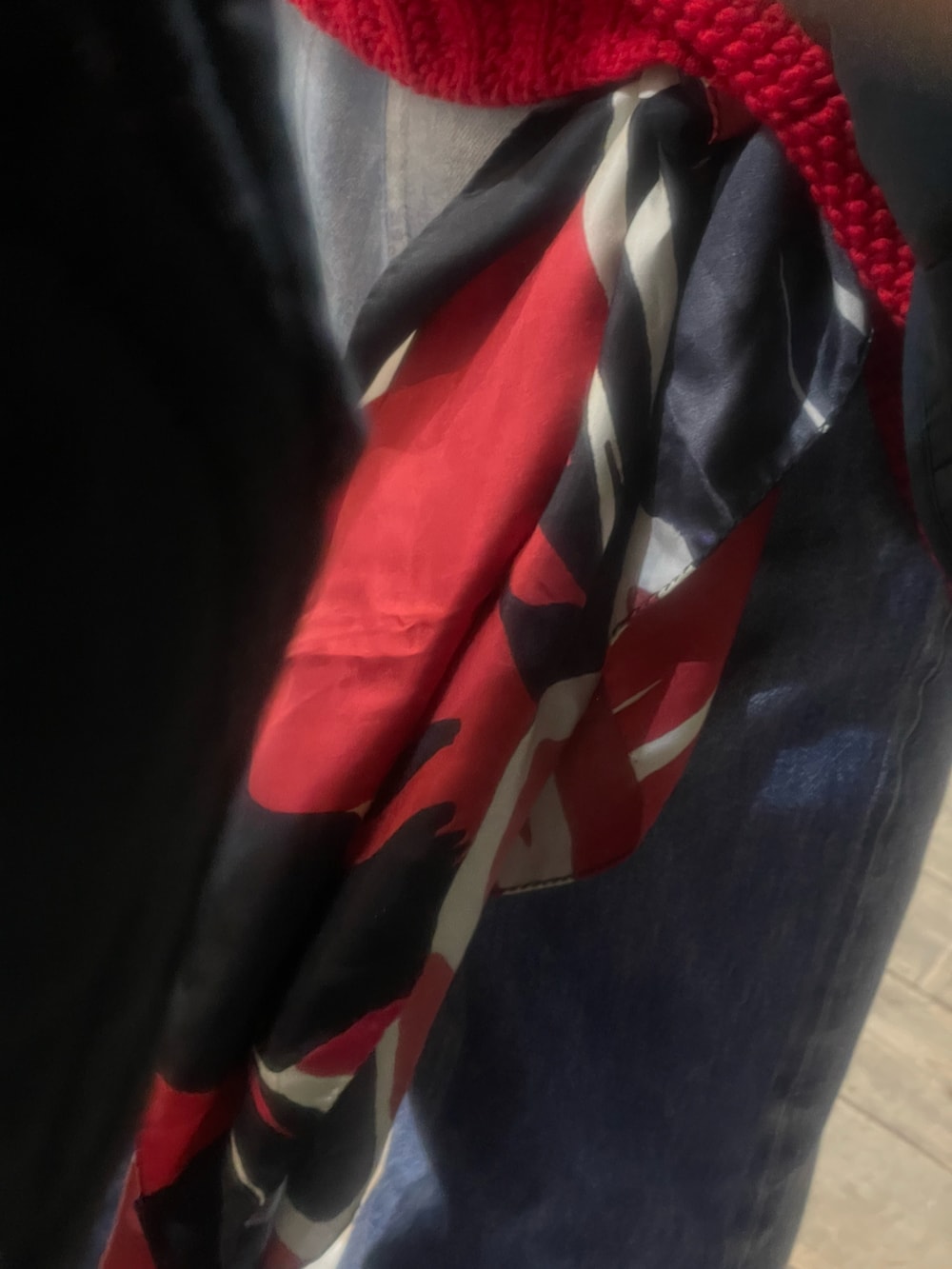 レッド系のニット/セーター、ホワイト系のブーツ、ブルー系のデニムパンツを着用したメンズの冬コーディネートの2枚目の写真