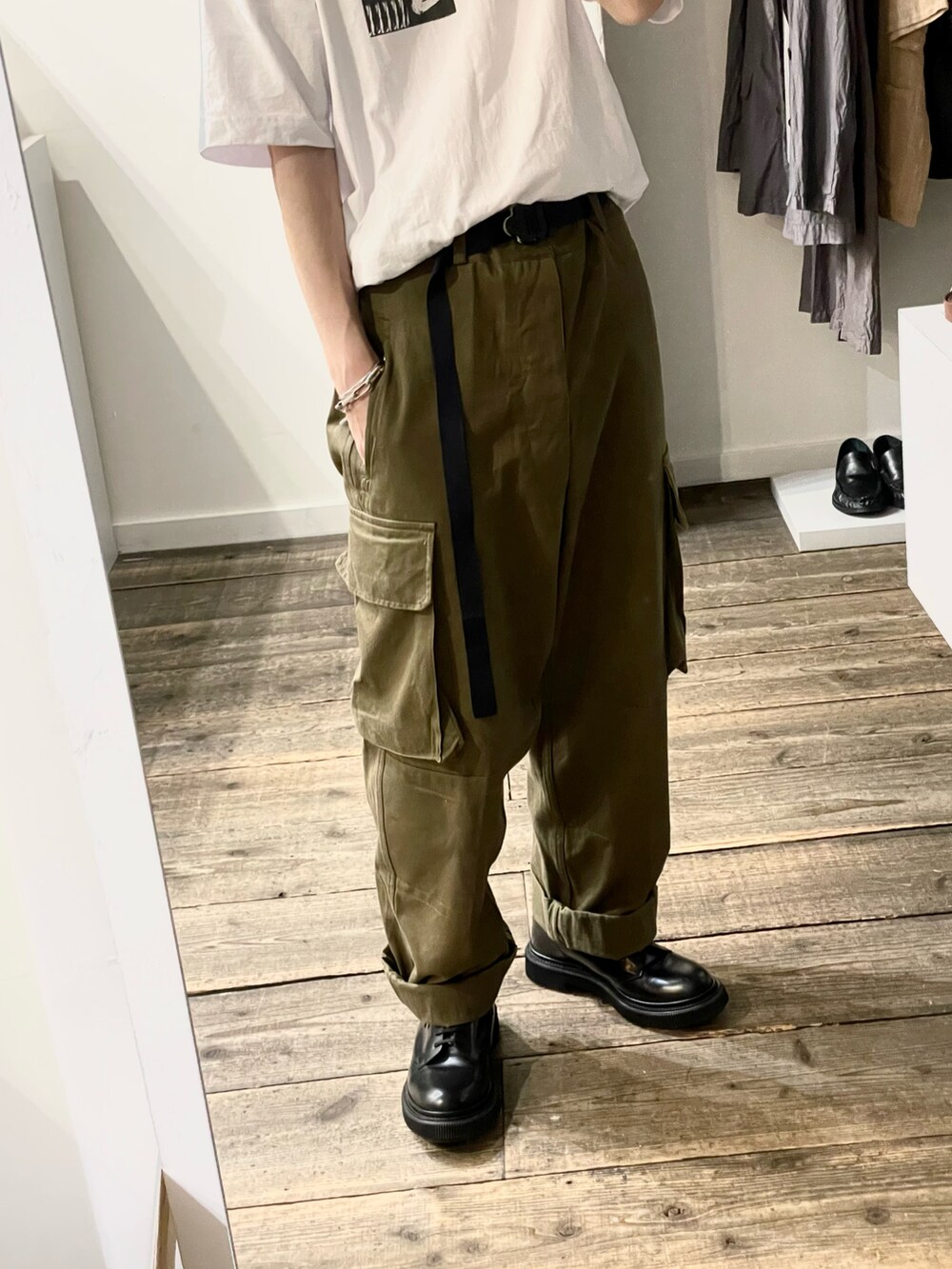 ホワイト系のTシャツ/カットソー、グリーン系のカーゴパンツ、ブラック系のブーツを着用したメンズの夏コーディネートの4枚目の写真