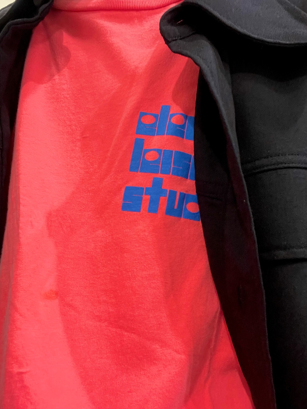 グリーン系のデニムパンツ、ブラック系のスニーカー、ブラック系のシャツ/ブラウスを着用したメンズの春コーディネートの2枚目の写真