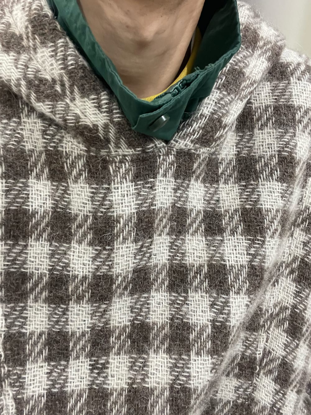 ブラウン系のその他アウター、ブラック系のスニーカー、ブラック系のネックレスを着用したメンズの冬コーディネートの2枚目の写真