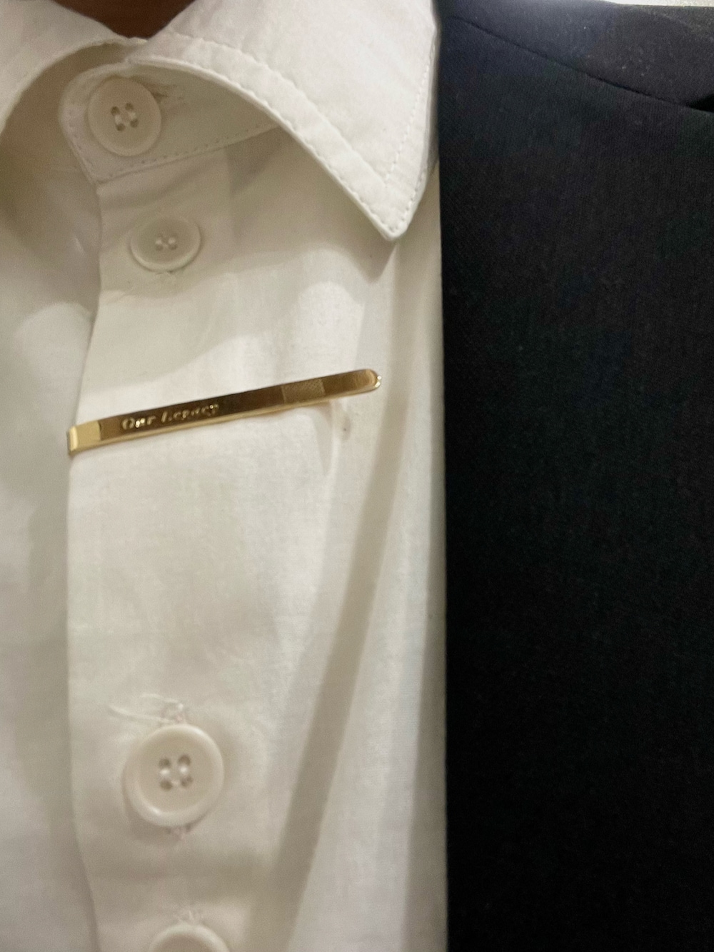 ブルー系のスニーカー、ブラック系のテーラードジャケット、ベージュ系のデニムパンツを着用したメンズの春コーディネートの3枚目の写真