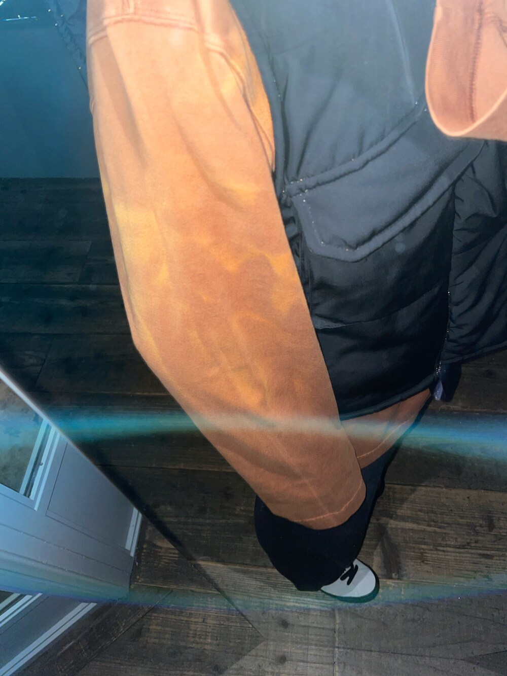 ブラック系のベスト、ホワイト系のスニーカー、ブラック系のデニムパンツを着用したメンズの春コーディネートの2枚目の写真