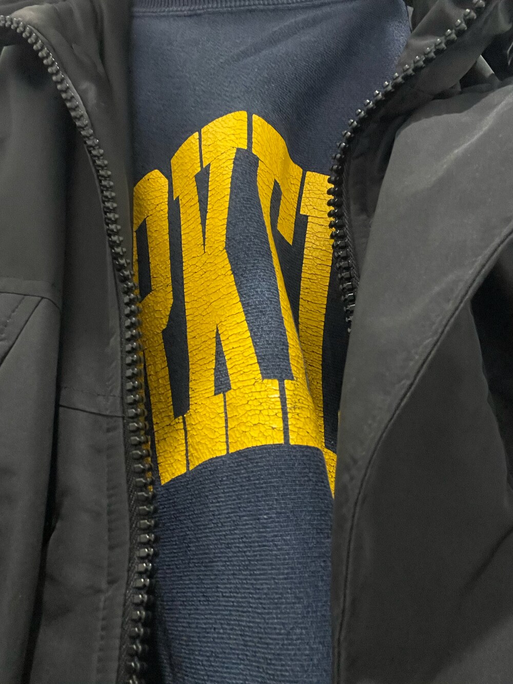 ブルー系のスウェット、ゴールド系のスニーカー、イエロー系のスラックスを着用したメンズの冬コーディネートの2枚目の写真