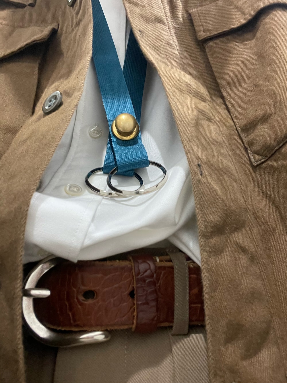 ベージュ系のスラックス、ブラウン系のスニーカー、ホワイト系のシャツ/ブラウスを着用したメンズの春コーディネートの2枚目の写真