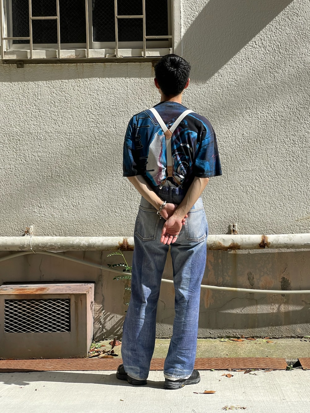 ブルー系のTシャツ/カットソー、ブルー系のデニムパンツ、ブラック系のスニーカーを着用したメンズの夏コーディネートの3枚目の写真