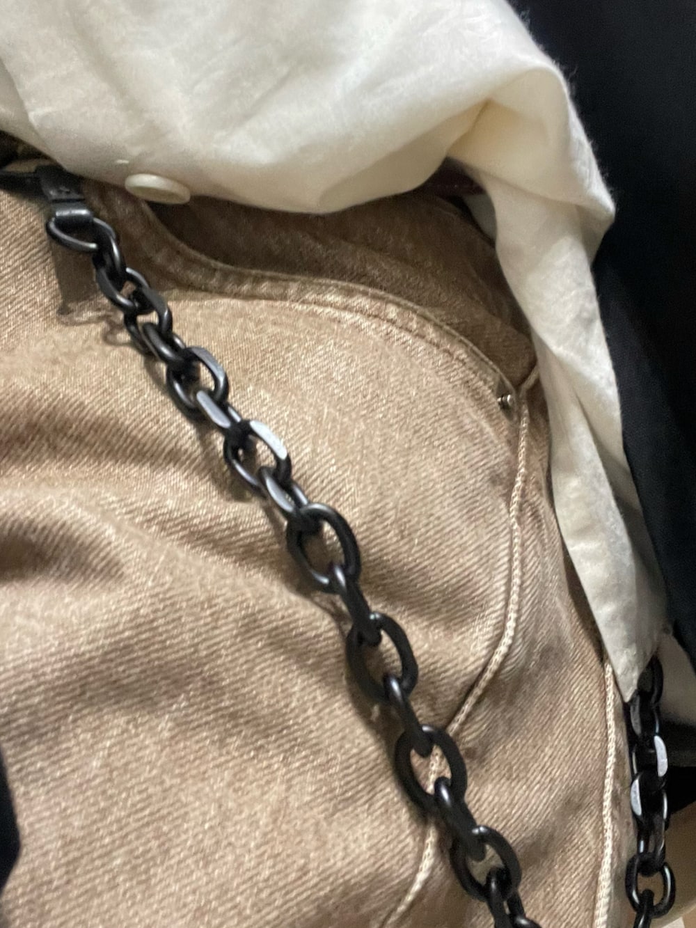 ブルー系のスニーカー、ブラック系のテーラードジャケット、ベージュ系のデニムパンツを着用したメンズの春コーディネートの4枚目の写真