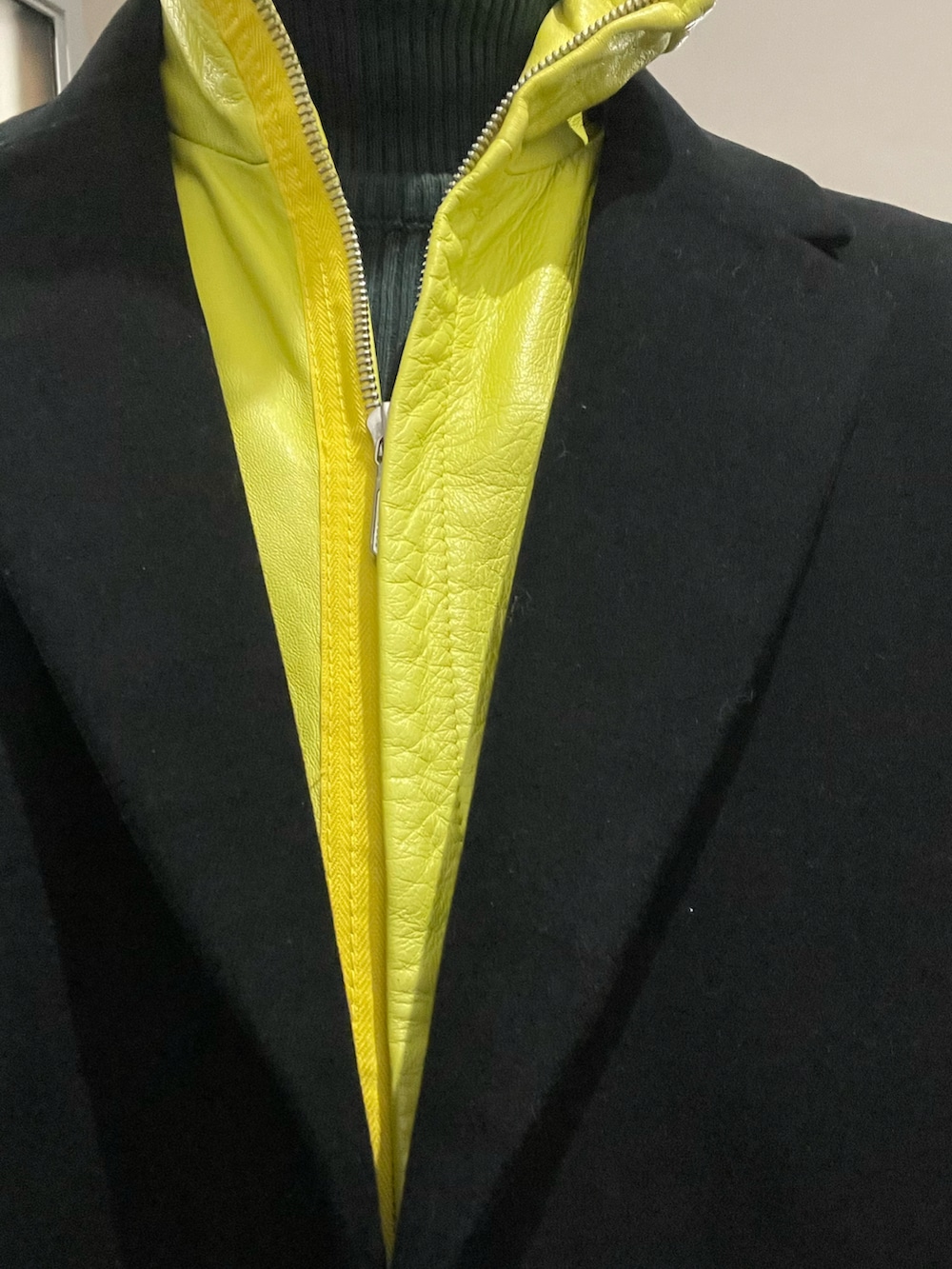 ブラック系のテーラードジャケット、イエロー系のベスト、ブラック系のスラックスを着用したメンズの冬コーディネートの2枚目の写真