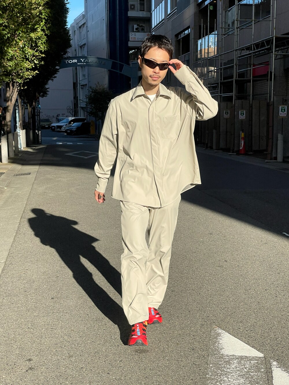 レッド系のスニーカー、ベージュ系のシャツ/ブラウス、ベージュ系のデニムパンツを着用したメンズの秋コーディネートの5枚目の写真