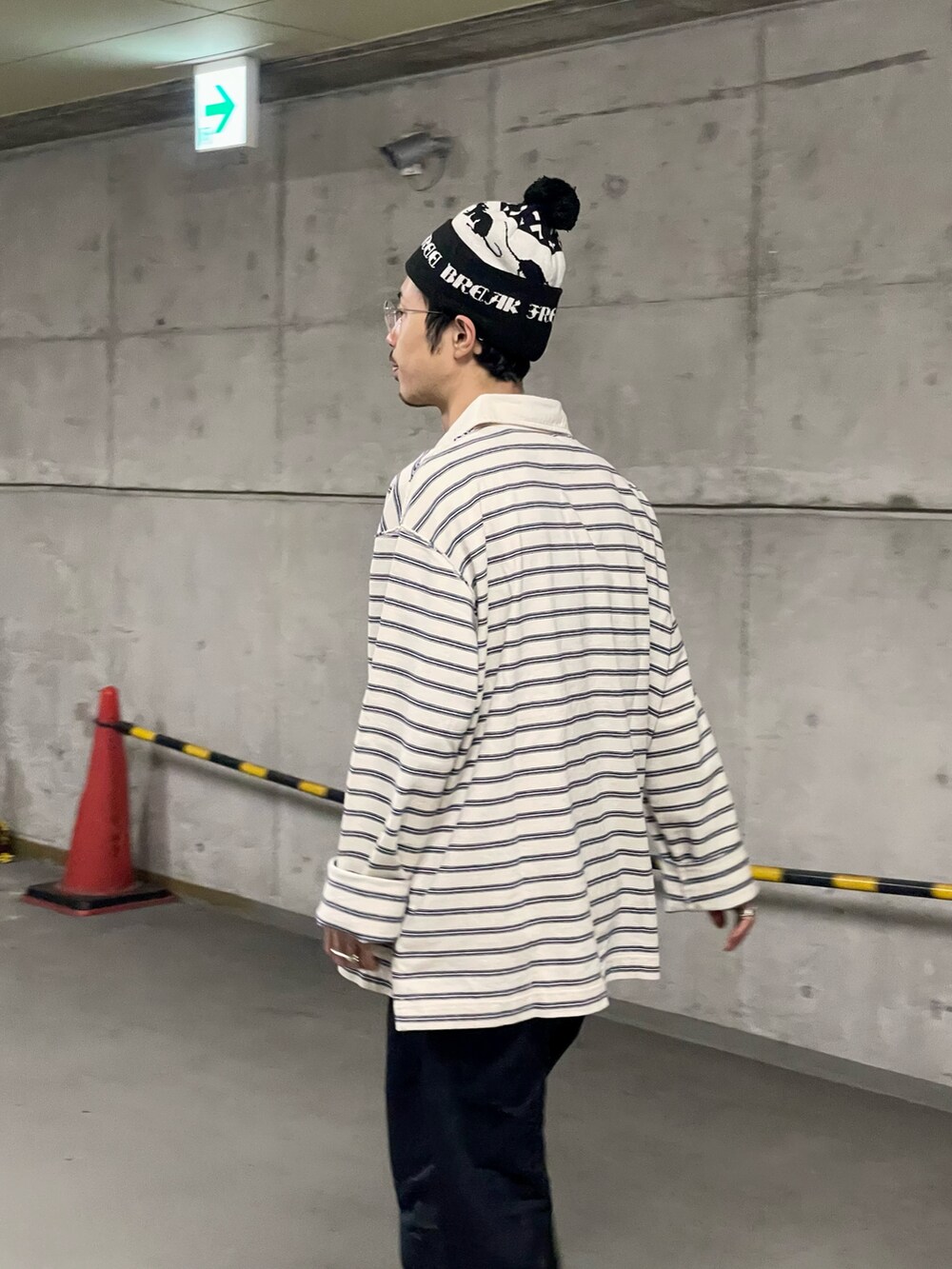 ブラック系のスラックス、ホワイト系のポロシャツ、シルバー系のスニーカーを着用したメンズの秋コーディネートの4枚目の写真