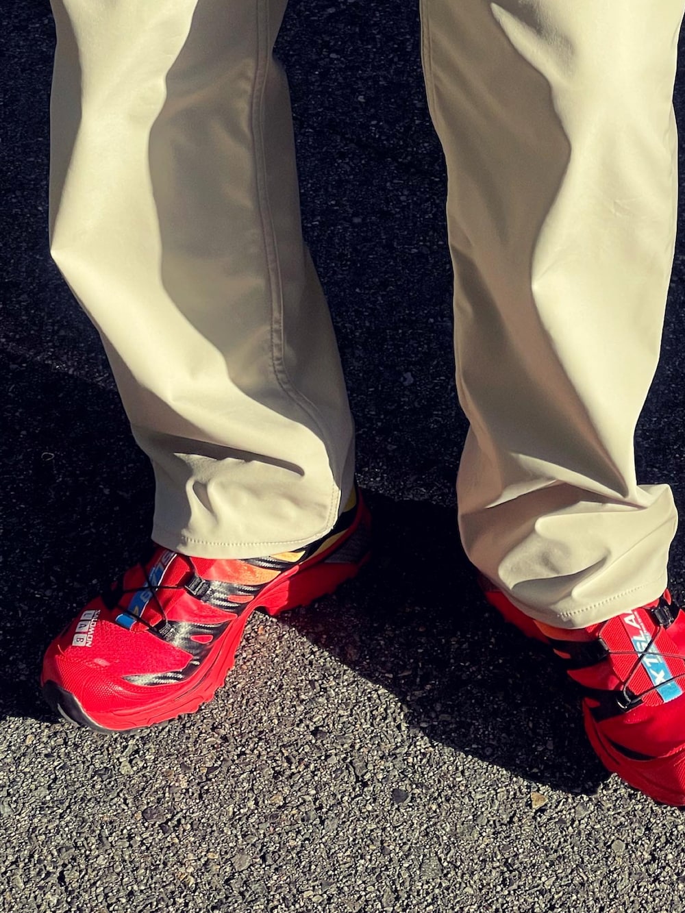 レッド系のスニーカー、ベージュ系のシャツ/ブラウス、ベージュ系のデニムパンツを着用したメンズの秋コーディネートの4枚目の写真