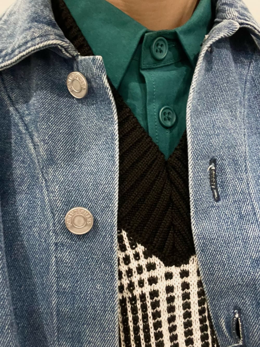 ホワイト系のベスト、ホワイト系のスニーカー、ブルー系のデニムジャケットを着用したメンズの春コーディネートの2枚目の写真