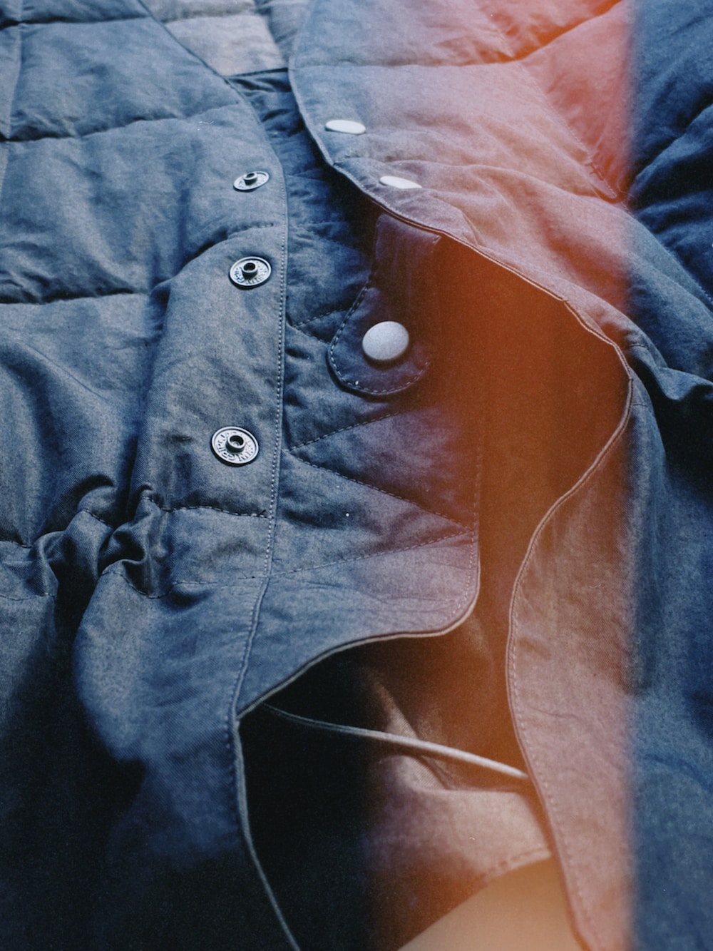 ブラウン系のベスト、ブラック系のデニムパンツ、ブラック系のスニーカーを着用したメンズの夏コーディネートの2枚目の写真