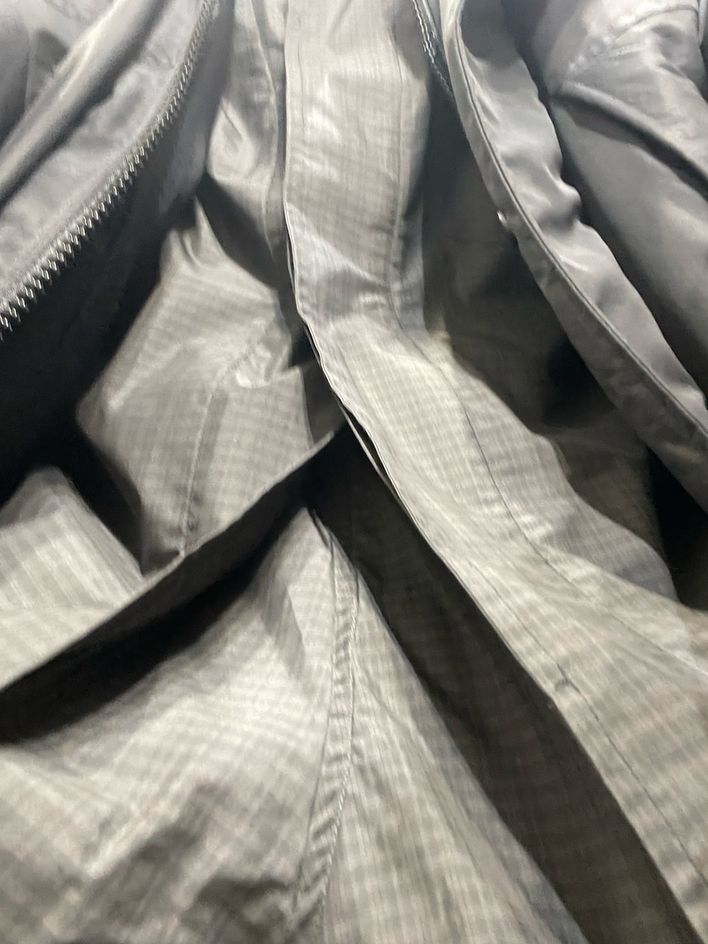 ブラック系のダウンジャケット/コート、グリーン系のスニーカー、グレー系のブルゾンを着用したメンズの春コーディネートの2枚目の写真