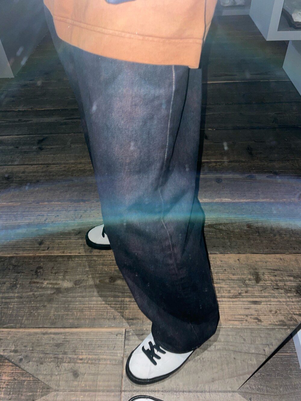 ブラック系のベスト、ホワイト系のスニーカー、ブラック系のデニムパンツを着用したメンズの春コーディネートの4枚目の写真