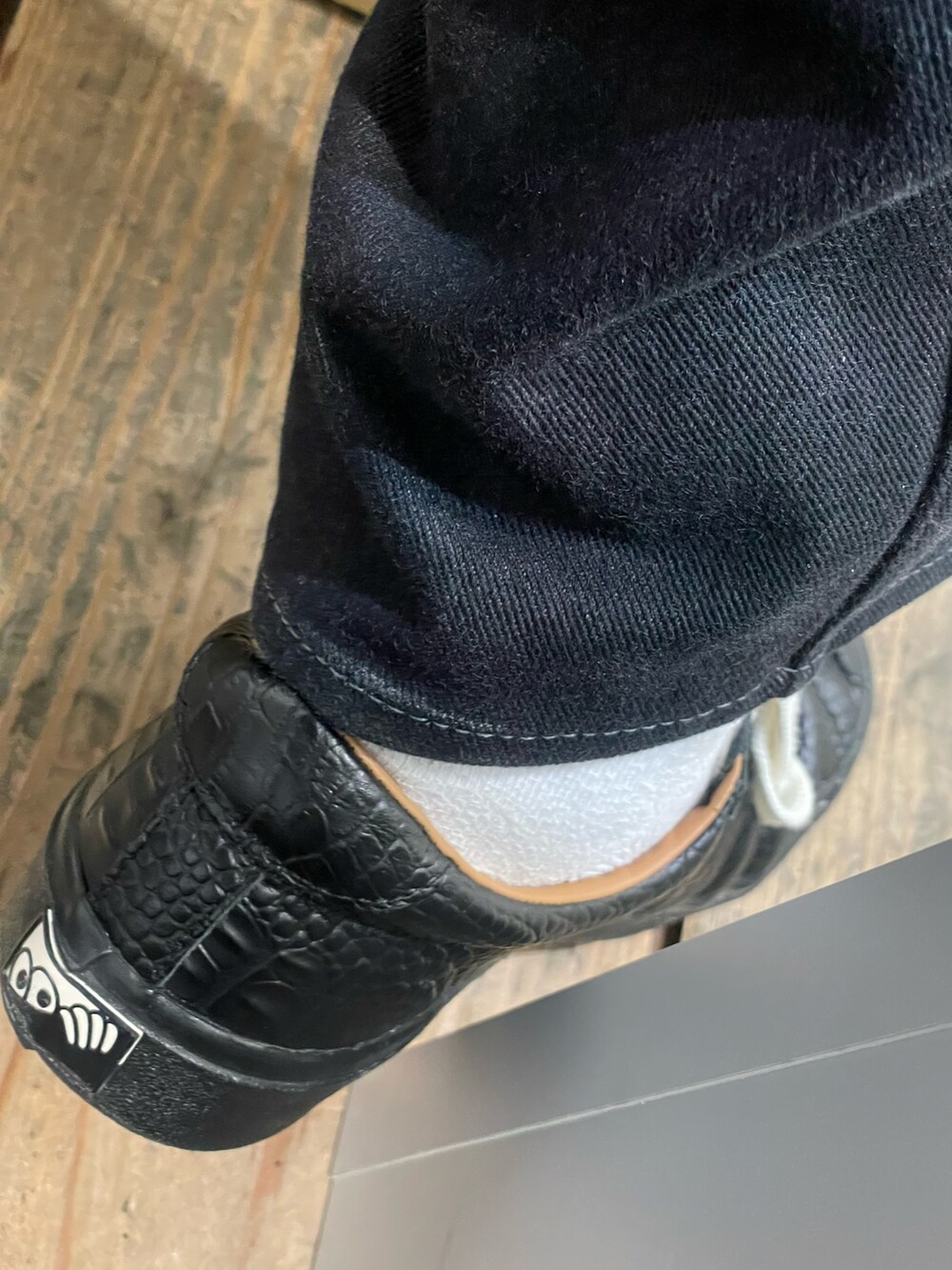 ブラウン系のベスト、ブラック系のデニムパンツ、ブラック系のスニーカーを着用したメンズの夏コーディネートの4枚目の写真