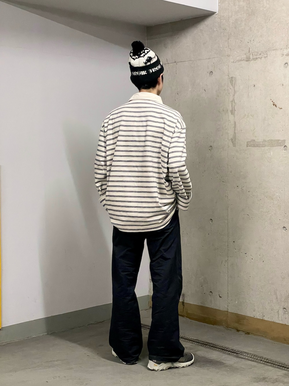 ブラック系のスラックス、ホワイト系のポロシャツ、シルバー系のスニーカーを着用したメンズの秋コーディネートの3枚目の写真