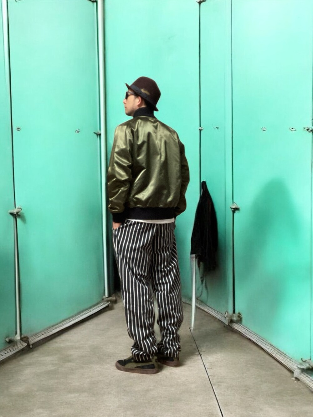 ブラック系のスニーカー、ブラック系のチノパンツ、グリーン系のブルゾンを着用したメンズの春コーディネートの2枚目の写真