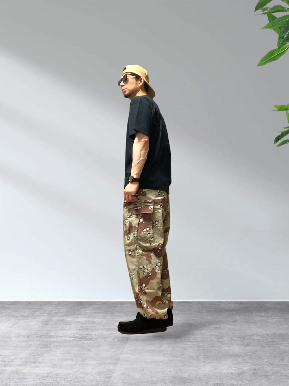 ベージュ系のカーゴパンツ、ブラック系のTシャツ/カットソー、ブラック系のモカシン/デッキシューズを着用したメンズの夏コーディネートの3枚目の写真